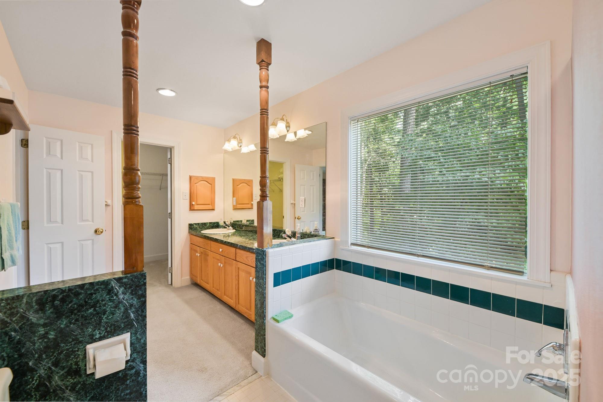 12041 Spinnaker Drive Tega Cay, SC 29708 - Photo 22 of 42 a bathroom with a tub sink and mirror