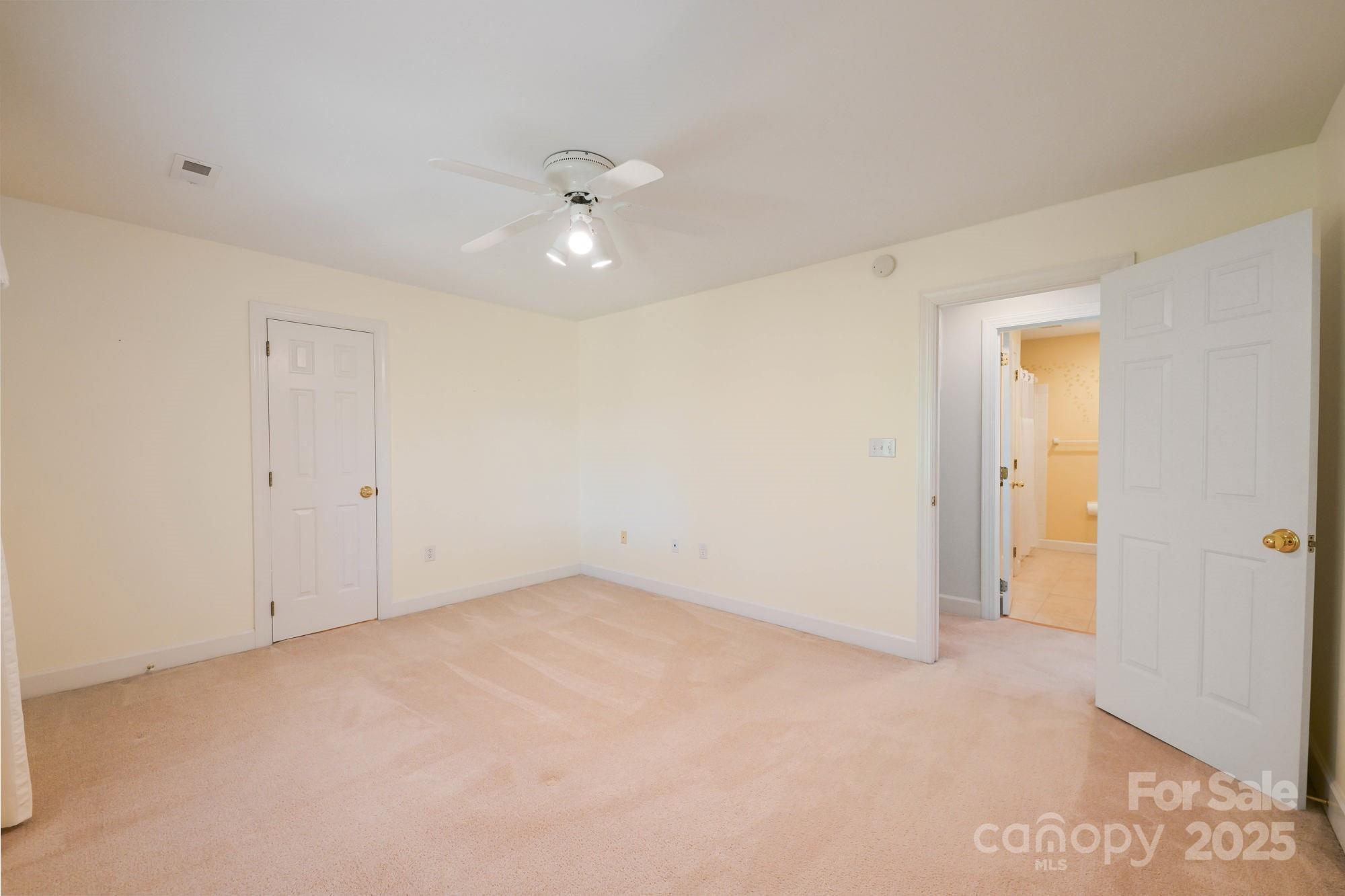 12041 Spinnaker Drive Tega Cay, SC 29708 - Photo 30 of 42 an empty room with a ceiling fan and carpet