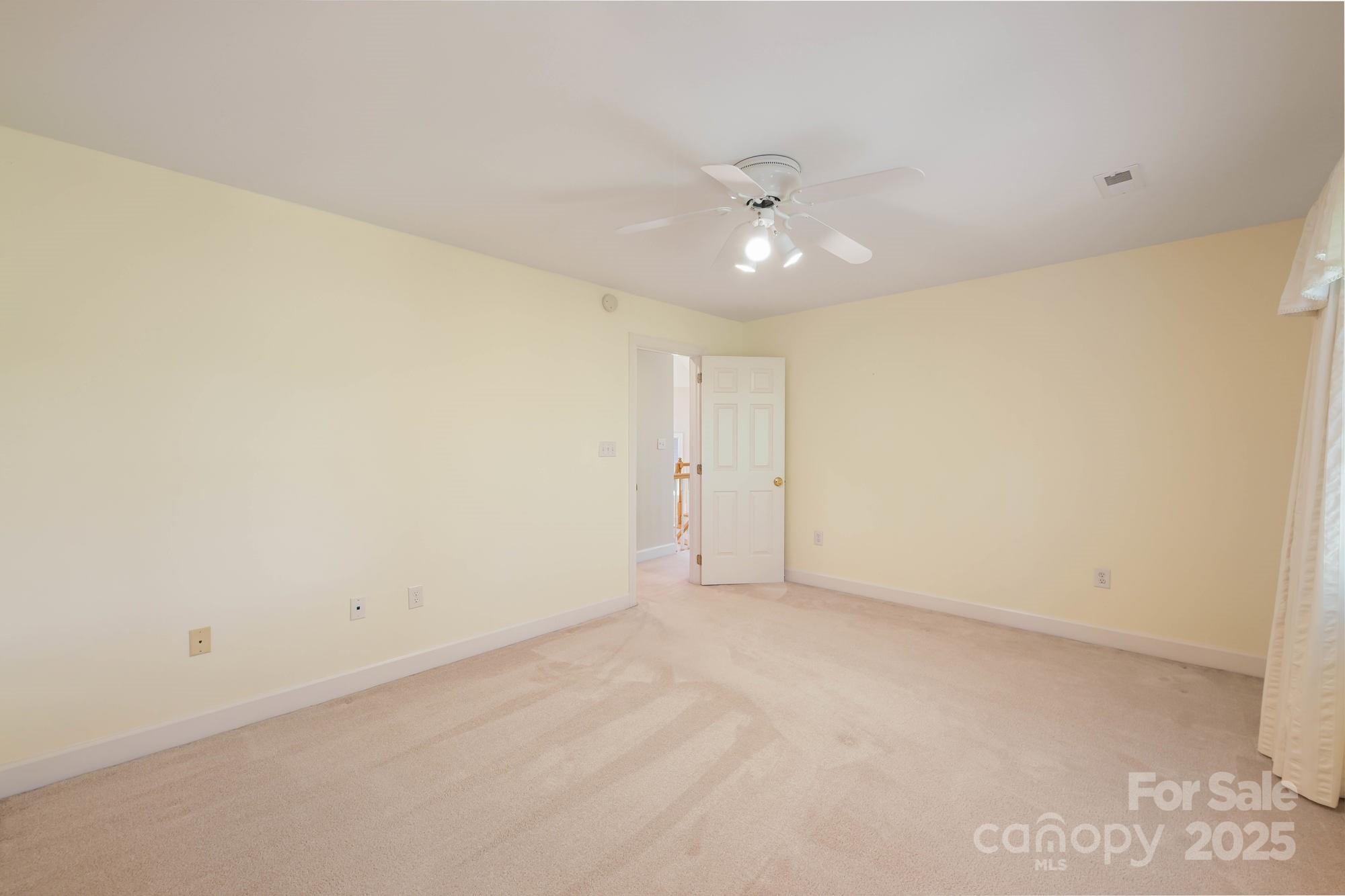 12041 Spinnaker Drive Tega Cay, SC 29708 - Photo 31 of 42 an empty room with a ceiling fan and a window