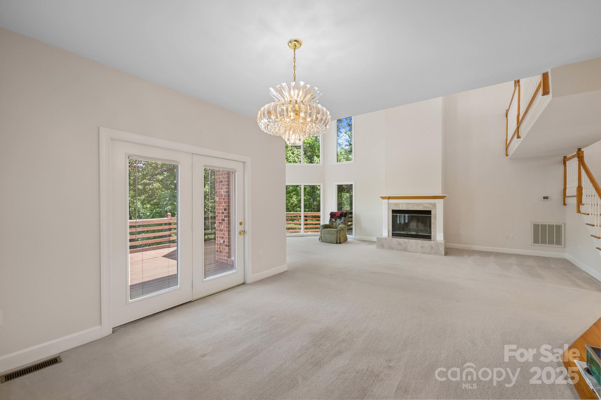 12041 Spinnaker Drive Tega Cay, SC 29708 - Photo 7 of 42 an empty room with windows and fireplace