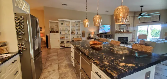 a kitchen with stainless steel appliances granite countertop a stove a sink and a refrigerator