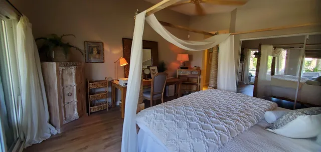 a bedroom with a large bed and a wooden floor