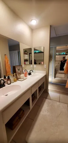 a bathroom with double vanity sink and a mirror