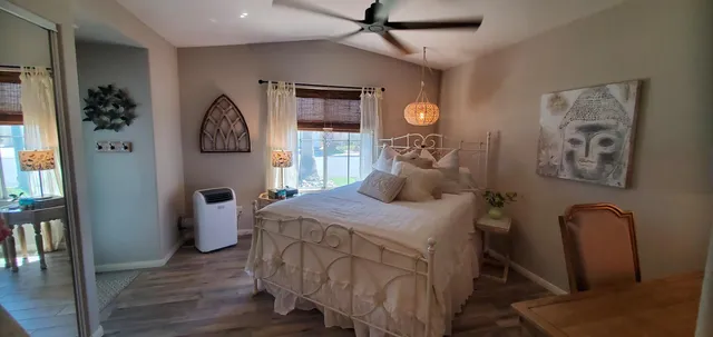 a bedroom with a bed a mirror and a window