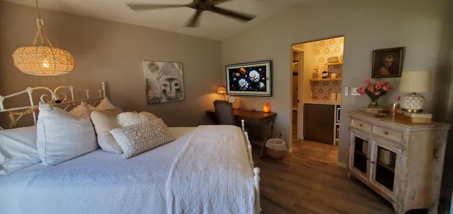 a bedroom with a bed and a mirror on the dresser