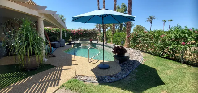 a view of a house with backyard sitting area and swimming pool