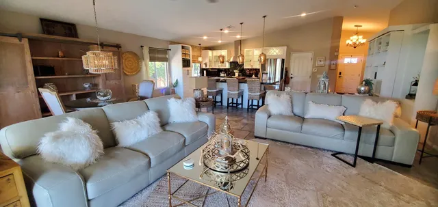 a living room with furniture dining area and a chandelier