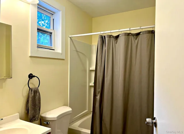 a spacious bedroom with a bed and wooden floor