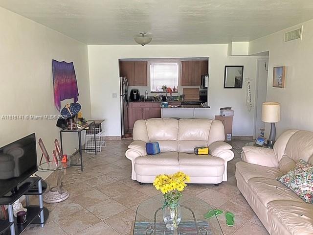 7580 Southwest 82nd Street, Unit F214 Miami, FL 33143 - Photo 3 of 13 a living room with furniture and a flat screen tv