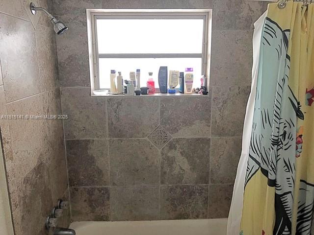 7580 Southwest 82nd Street, Unit F214 Miami, FL 33143 - Photo 7 of 13 a bathroom with a bathtub and a window