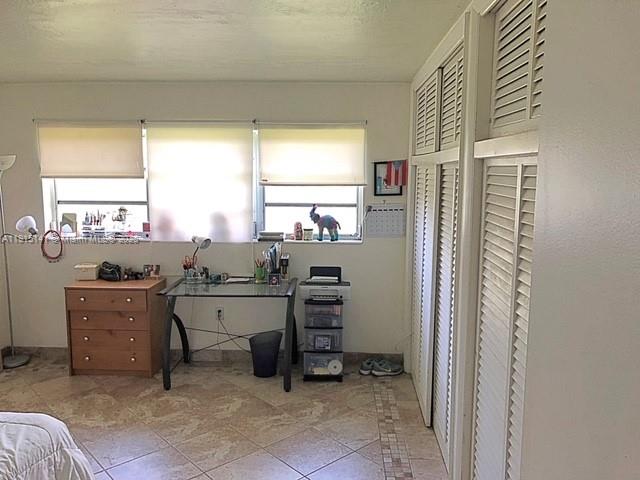 7580 Southwest 82nd Street, Unit F214 Miami, FL 33143 - Photo 9 of 13 a room with a chair and a table
