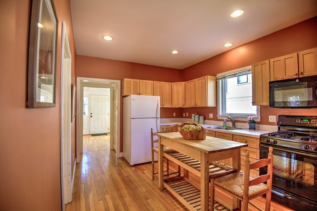14 Argilla Road Ipswich, MA 01938 - Photo 2 of 28 a kitchen with a table chairs refrigerator and microwave