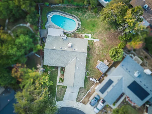 an aerial view of a house with table and chairs and potted plants
