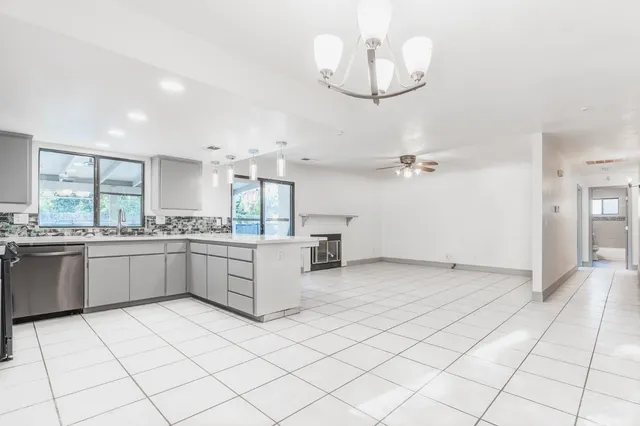 a large white kitchen with a lot of cabinets and appliances