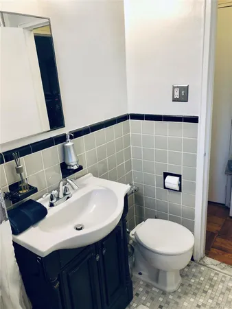 a bathroom with a sink a toilet and mirror