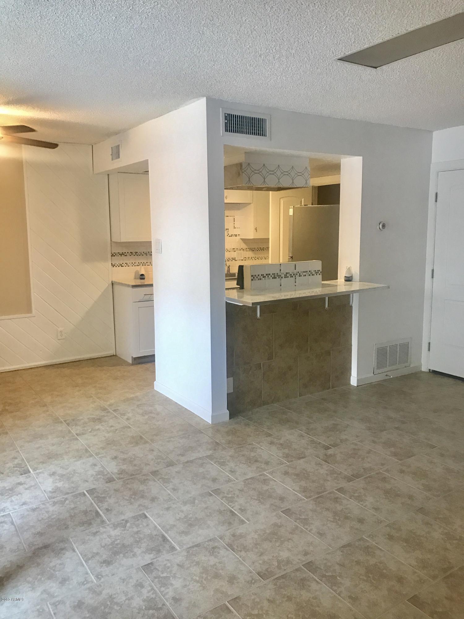 3951 West Wonderview Road Phoenix, AZ 85019 - Photo 3 of 25 a view of an empty room with window and cabinet