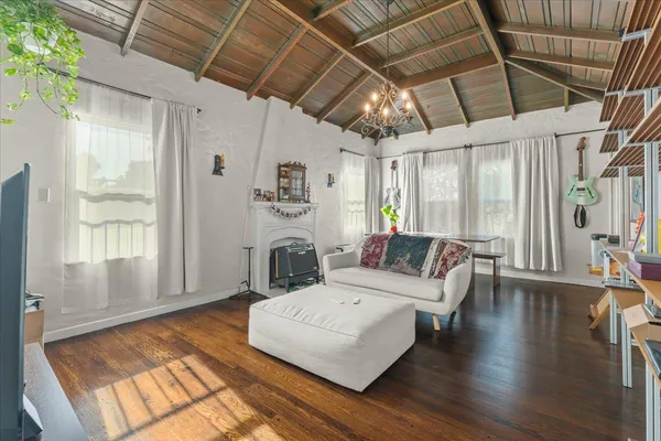an empty room with wooden floor cabinet and windows
