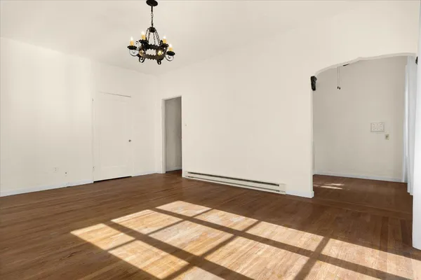 a view of a room with wooden floor and a ceiling fan