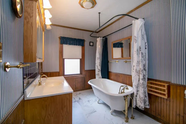 a bathroom with a sink a bathtub and a window
