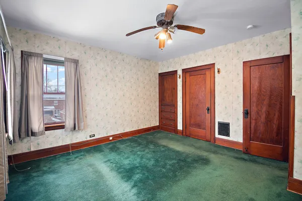 a view of an empty room with window and cabinet