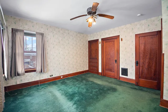 a view of an empty room with window and cabinet
