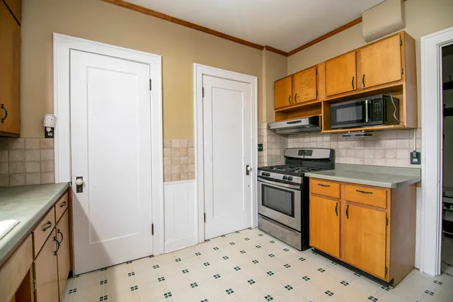 a kitchen with stainless steel appliances granite countertop a stove a sink and a microwave