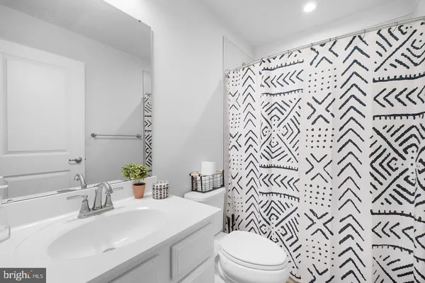 a bathroom with a sink mirror vanity and toilet