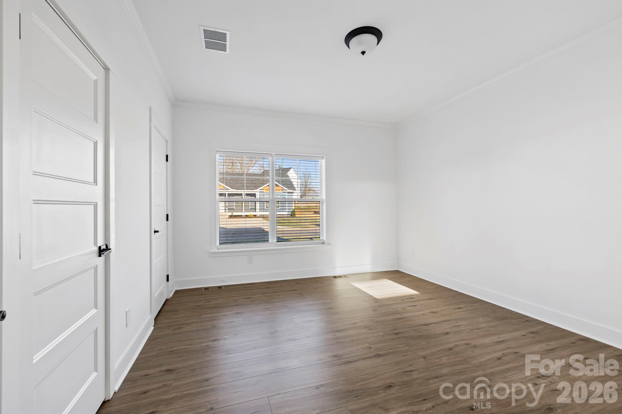 203 Southern Charm Road Arden, NC 28704 - Photo 13 of 34 a view of an empty room with wooden floor and a window