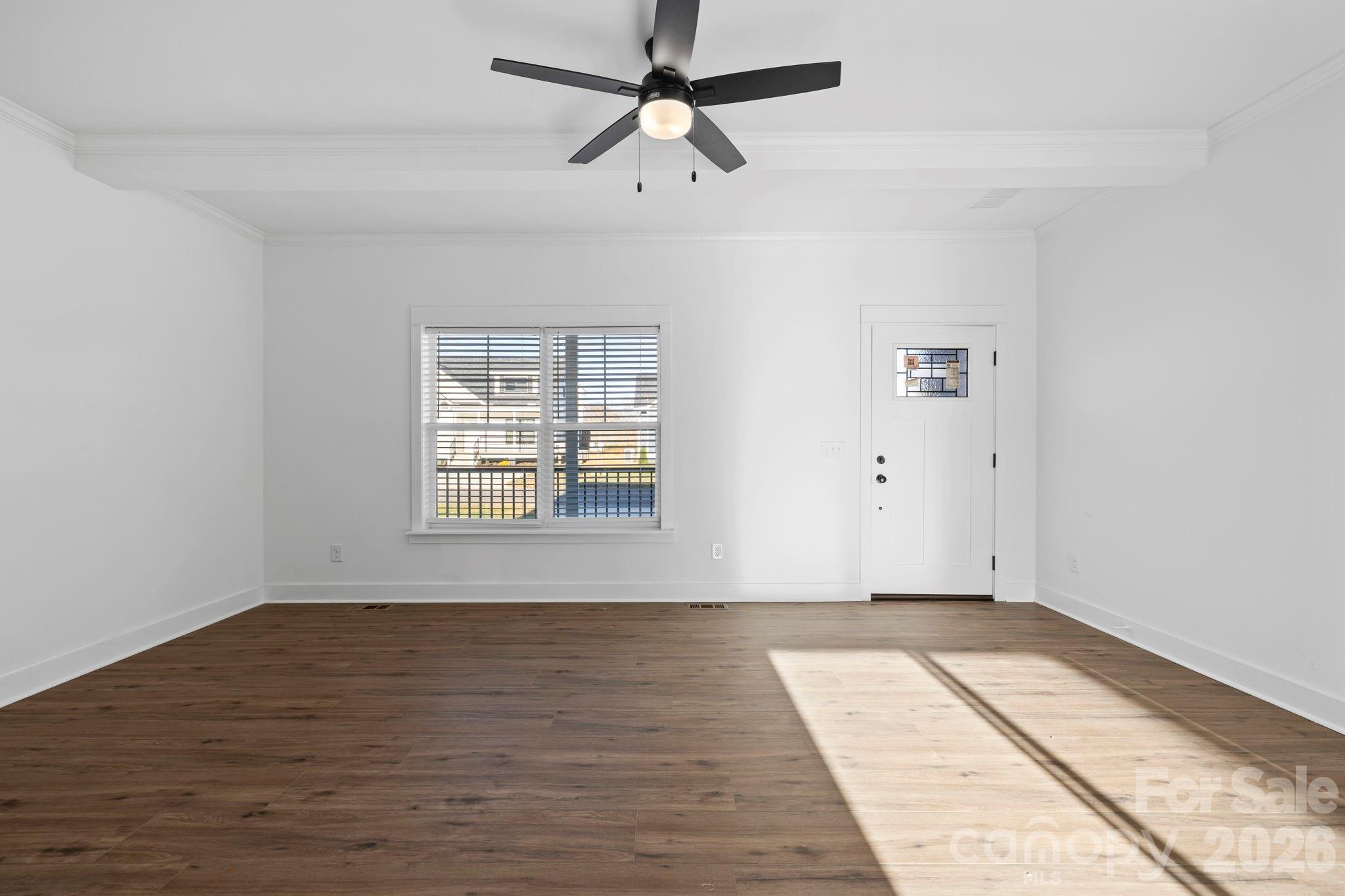 203 Southern Charm Road Arden, NC 28704 - Photo 7 of 34 an empty room with wooden floor chandelier fan and windows