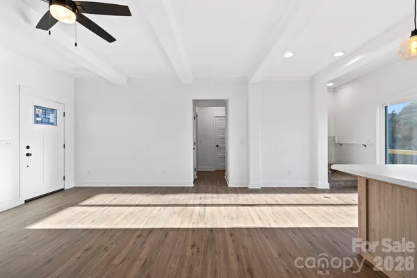 a view of an empty room with wooden floor
