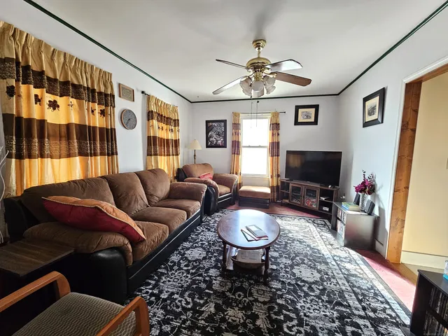 a living room with furniture a flat screen tv and a window