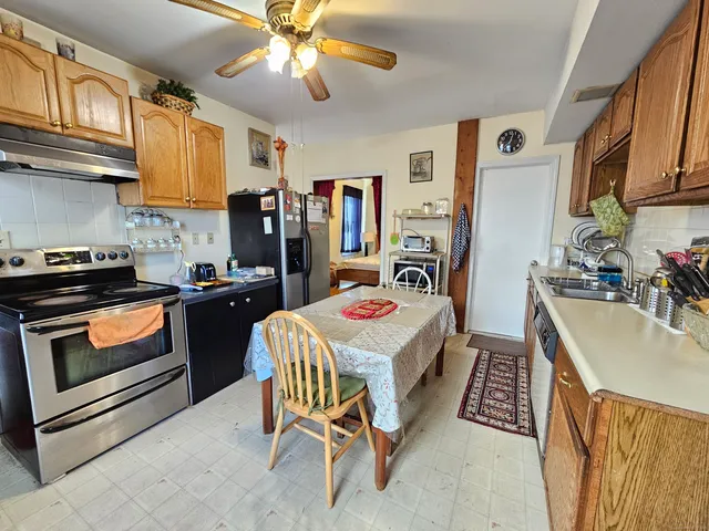 a kitchen that has a table chairs and a refrigerator