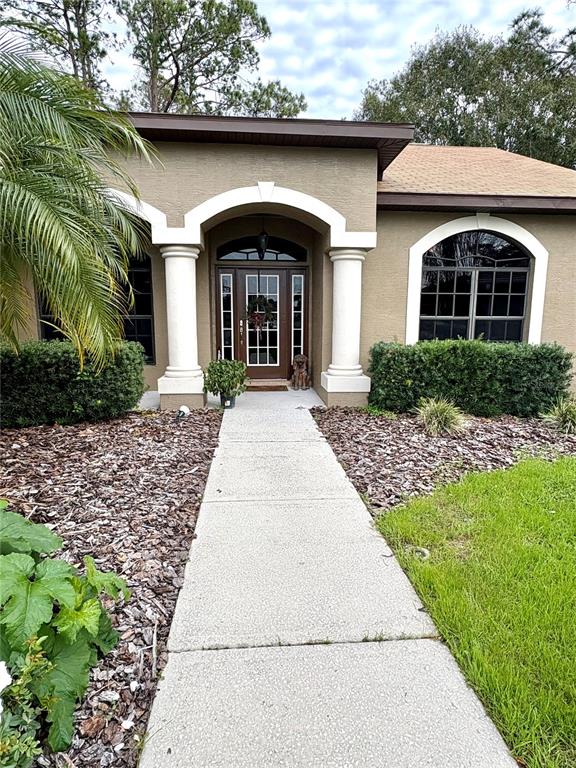 7964 Roundelay Drive New Port Richey, FL 34654 - Photo 2 of 27 a front view of a house with garden