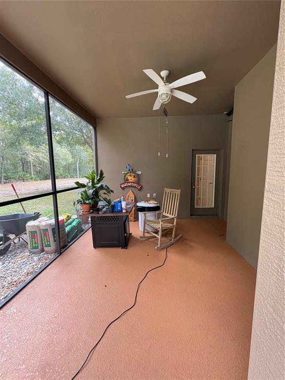 7964 Roundelay Drive New Port Richey, FL 34654 - Photo 22 of 27 a living room with furniture a ceiling fan and a large window