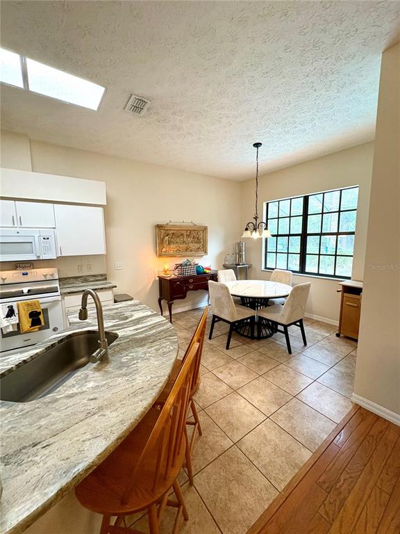 7964 Roundelay Drive New Port Richey, FL 34654 - Photo 9 of 27 a dining room with stainless steel appliances granite countertop a sink a counter space and dining table