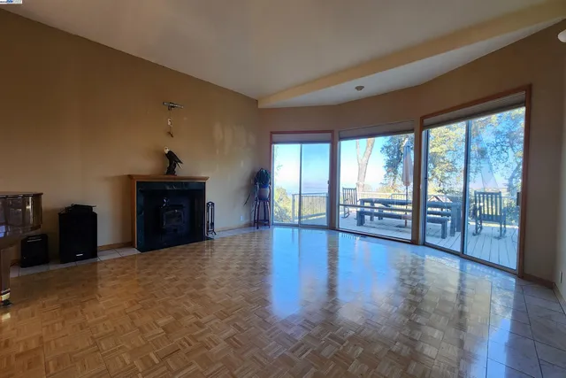 an empty room with wooden floor closet and windows