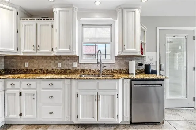 a kitchen with granite countertop white cabinets and sink