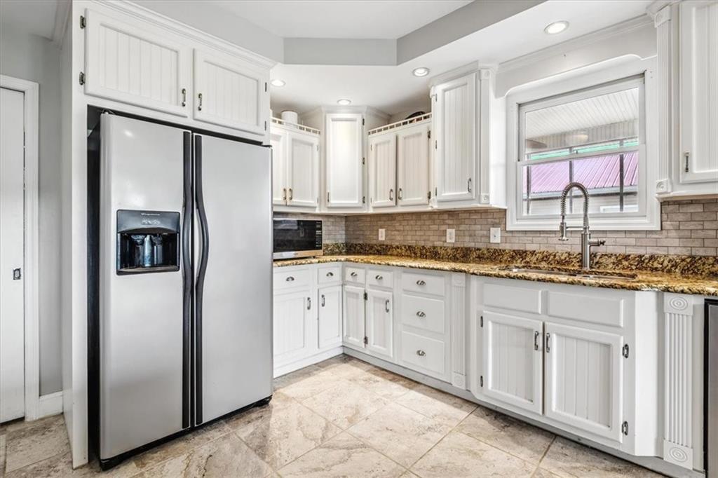 231 Gordon Road Cedartown, GA 30125 - Photo 13 of 49 a kitchen with granite countertop a refrigerator sink and white cabinets
