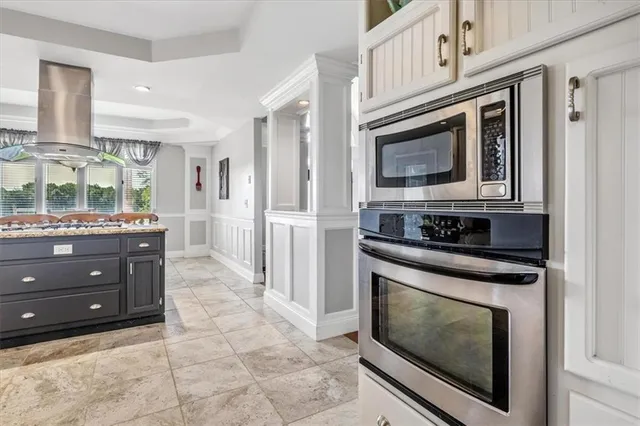 a kitchen with stainless steel appliances granite countertop a stove microwave and cabinets