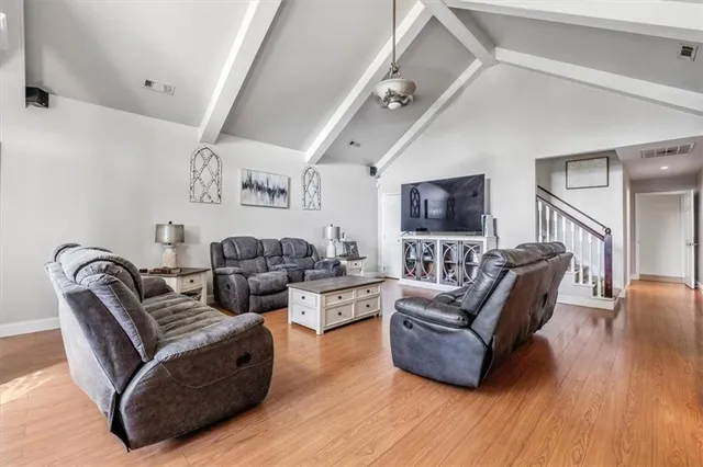 a living room with furniture flat screen tv and wooden floor