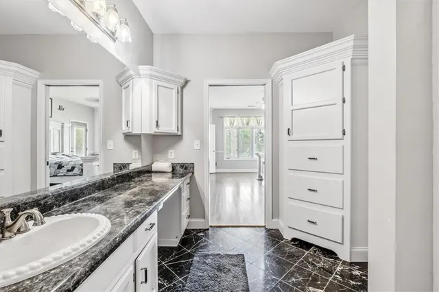 a spacious bathroom with a granite countertop sink and a mirror