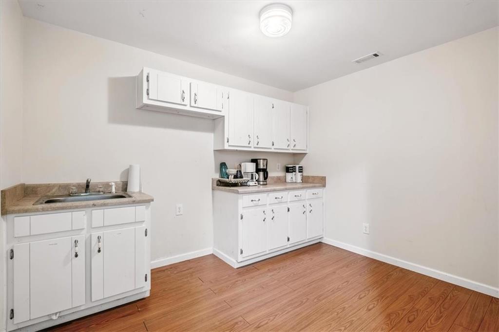 231 Gordon Road Cedartown, GA 30125 - Photo 38 of 49 a kitchen with granite countertop white cabinets and a wooden floor