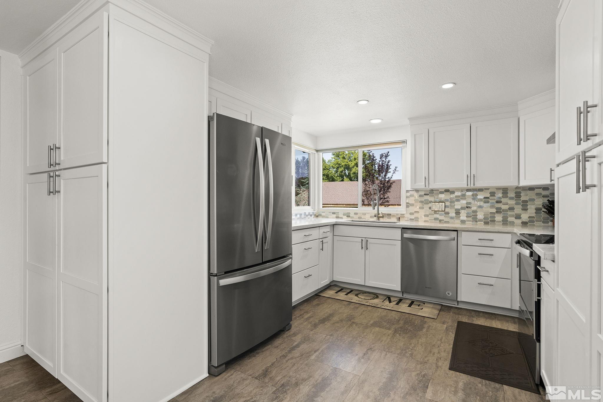915 Pinebrook Road Reno, NV 89509 - Photo 11 of 29 a kitchen with a refrigerator stove and white cabinets