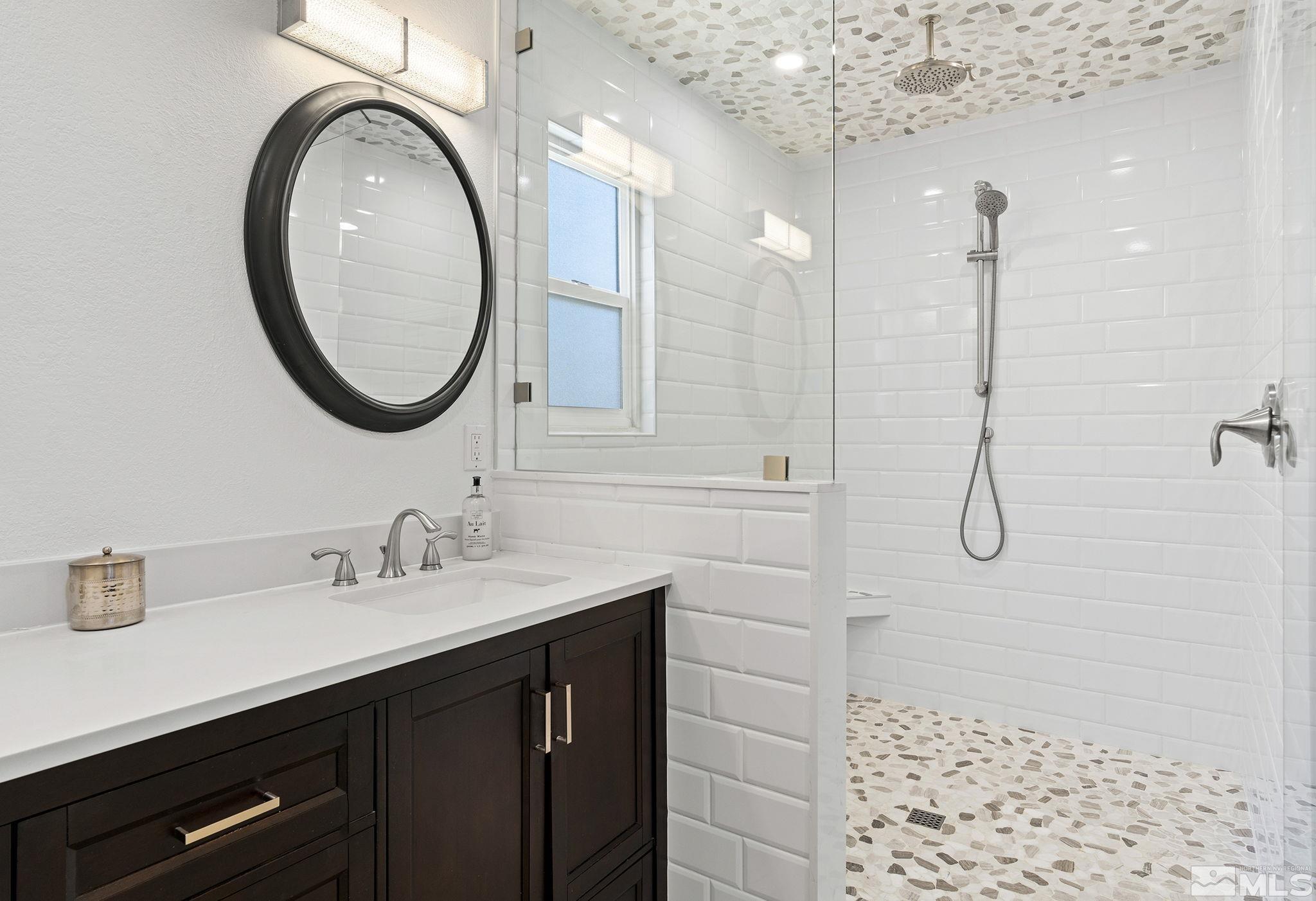 915 Pinebrook Road Reno, NV 89509 - Photo 16 of 29 a bathroom with a sink a vanity a mirror and shower