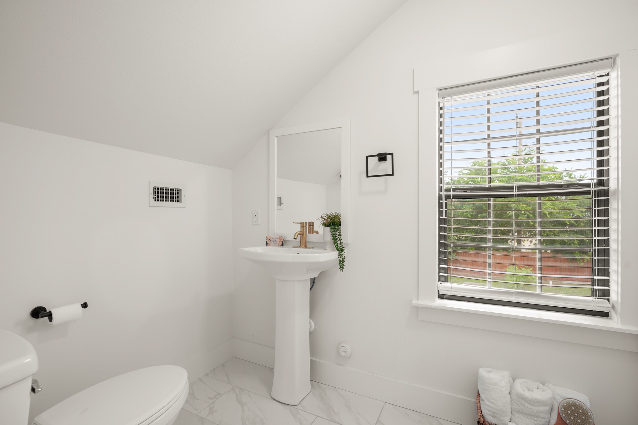 301 Old Thorndale Road Taylor, TX 76574 - Photo 16 of 29 A well-lit powder room featuring a sleek pedestal sink and marble-look tile flooring.