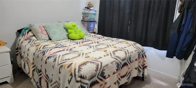 a bedroom with a bed and painting on the wall