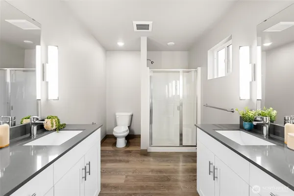 a bathroom with a granite countertop sink a toilet and shower