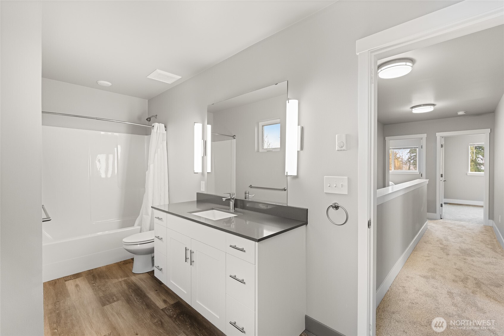 1884 Front Street, Unit A Lynden, WA 98264 - Photo 24 of 35 a bathroom with a granite countertop sink a toilet a mirror and shower