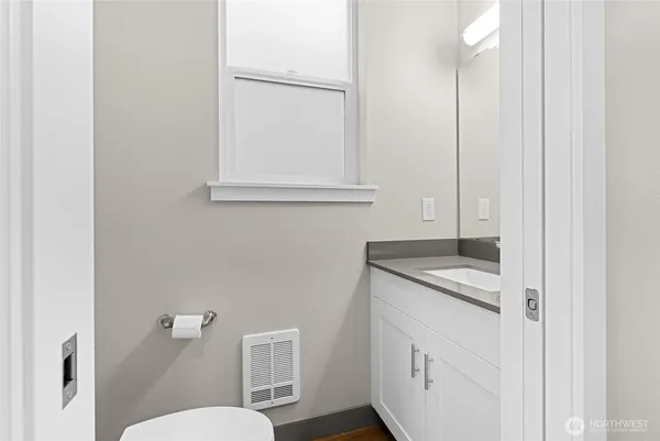 a bathroom with a granite countertop sink and a toilet