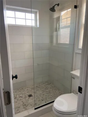 a white toilet sitting next to a shower